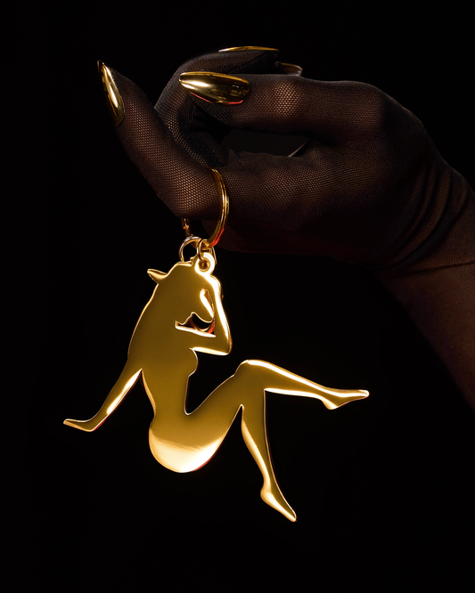 Beyoncé Lady Bey gold charm keychain held with black glove in close-up luxury product shot