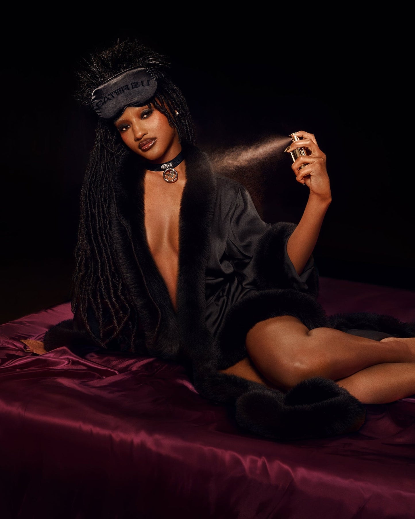CÉ LUMIÈRE BODYGUARD lifestyle shot featuring black robe, sleep mask, choker, and perfume spray